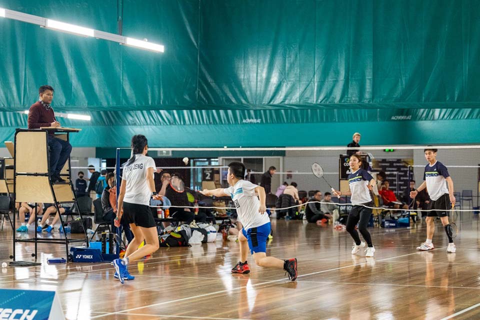 Indoor mixed doubles badminton game 