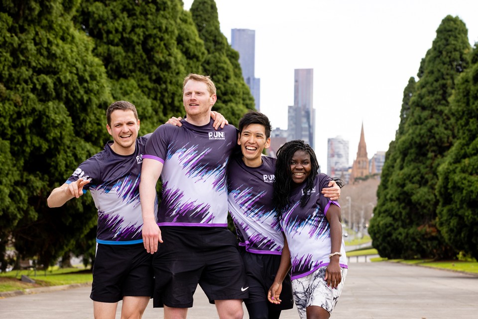 Runners posing for a team photo in a park
