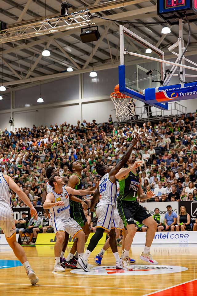Players look up to the ball as it hits the rim of the basket.