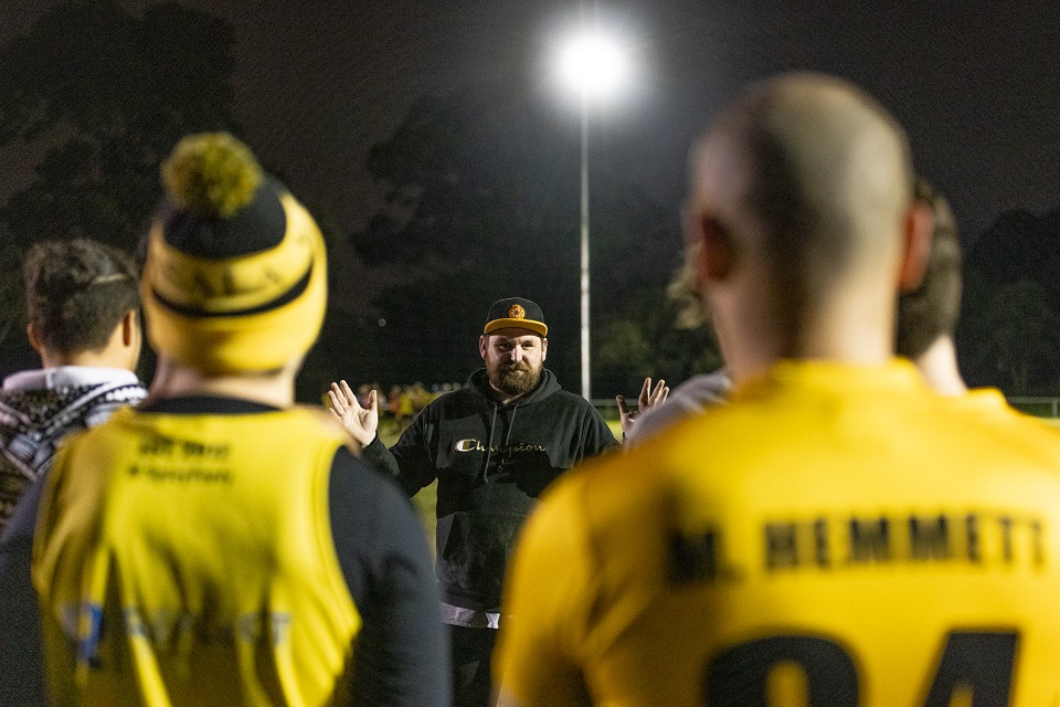 Footy coach talking to the team at training