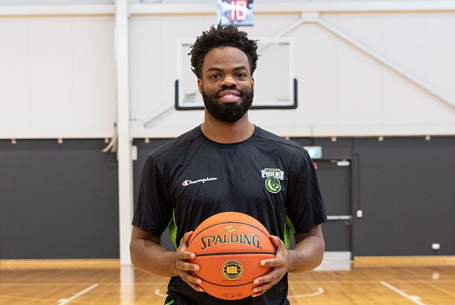 South East Melbourne Phoenix point guard Derrick Walton Jr holding a basketball.