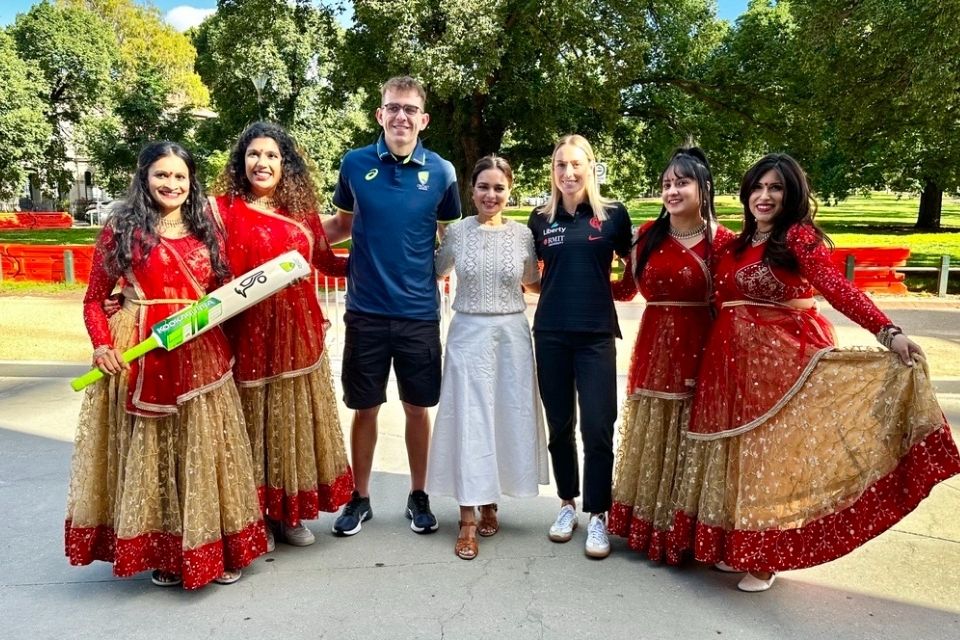 Cricketers Todd Murphy and Nicole Faltum, celebrity chef Kishwar Chowdhury and local Indian dancers pose for photo outside Melbourne Cricket Ground.