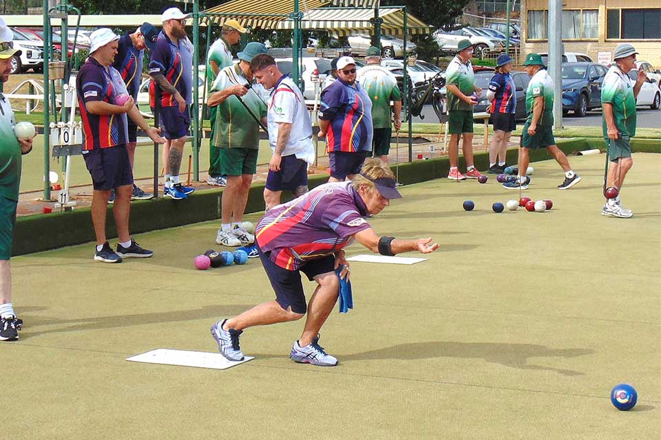 Uniformed players compete in a lawn bowls tournament.
