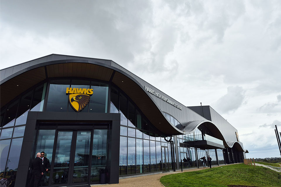 A building with a Hawthorn 'Hawks' football club logo above the front doors and 'HARRIS HIGH PERFORMANCE CENTRE' written on the side.