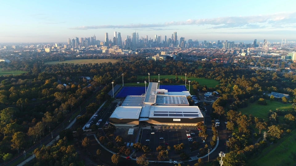 Aerial photograph showing Melbourne Sport Centres Parkville with the Melbourne city skyline in the background.