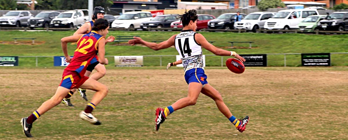 Community football players on the field, engaged in a game of Australian Rules football.