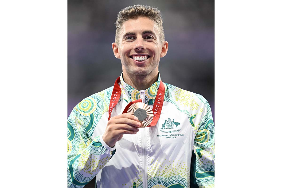 Paralympian Reece Langdon wearing an Australian uniform and holding his bronze medal.