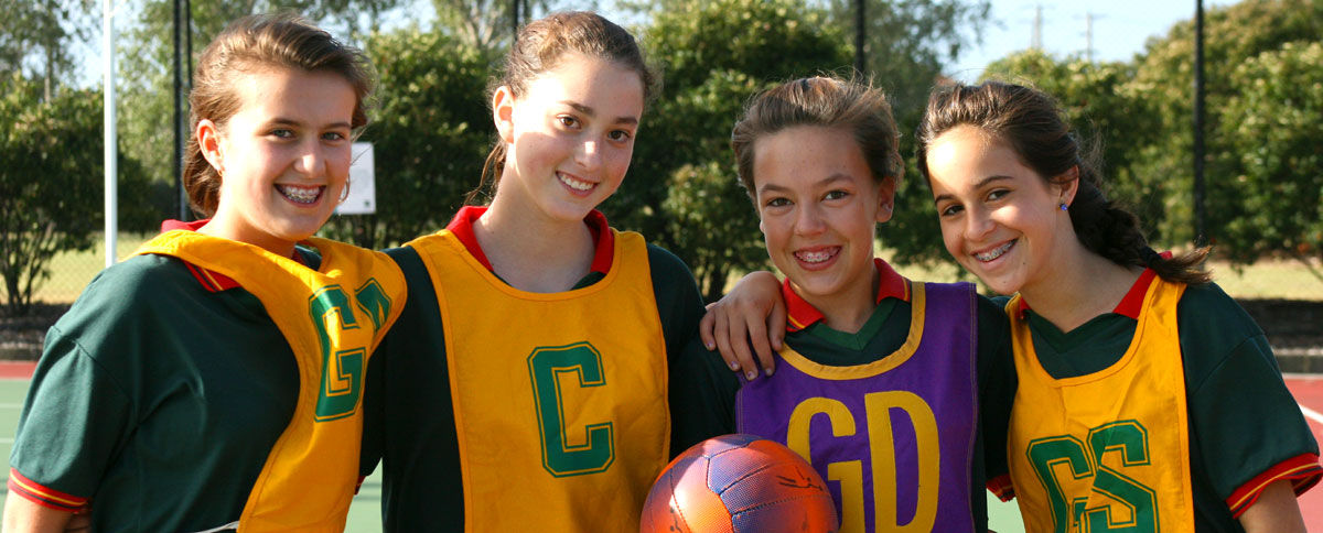 Smiling netballers on an outdoor netball court